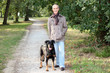 Senior man walking his dog in the woods
