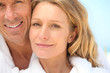Couple wearing bath robes stood outside