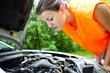 Young driver bent over the car engine