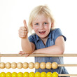 Foto: Blonde little girl learning with an abacus shows thumb up Blonde little girl learning with an abacus shows thumb up