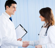 Photo: Two happy young medical people handshaking Two happy young medical people handshaking