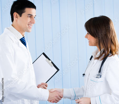 Foto: Two happy young medical people handshaking Two happy young medical people handshaking