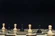 Playing pawns diagonally on a chessboard, black background