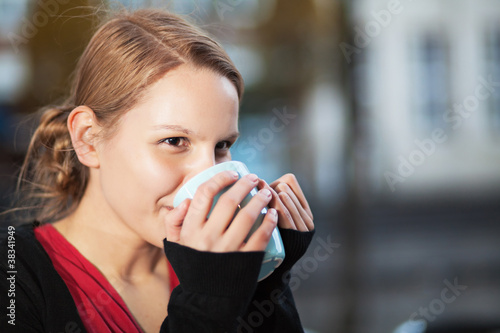 Photo: Pretty young woman with cup of chocomilk Pretty young woman with cup of chocomilk