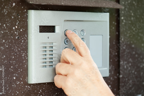 Photo: finger pushing button of intercom finger pushing button of intercom