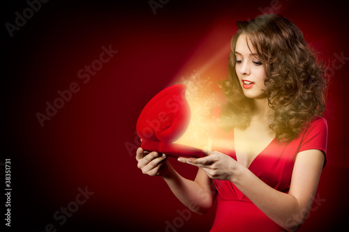 Photo: Happy girl opening a gift on Valentine's Day Happy girl opening a gift on Valentine's Day