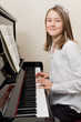 Happy young girl playing the piano