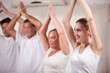 Happy group of people practising yoga