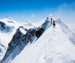 Climbers balancing in blizzard on a narrow ridge