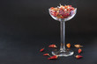 Red hot chili peppers in a liqueur glass with black background