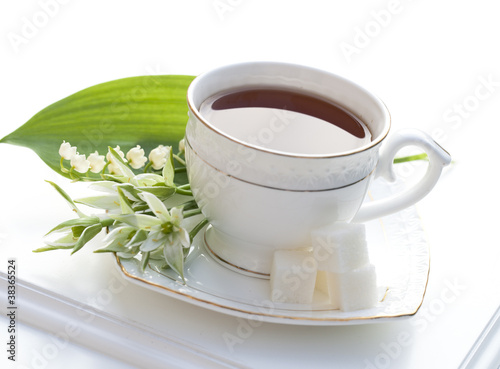 Foto: tea in a cup of white flowers and lilies of the valley tea in a cup of white flowers and lilies of the valley