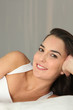 Brunette resting on bed