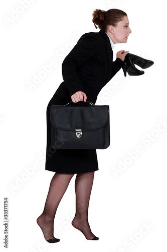 Photo: Woman sneaking out of the office Woman sneaking out of the office