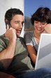Couple in the sunshine with a laptop and phone