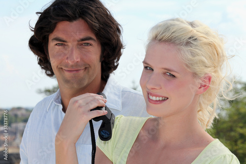 Photo: Couple walking with pair of binoculars Couple walking with pair of binoculars