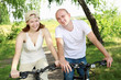 Photo: Young couple on the bikes in the park Young couple on the bikes in the park