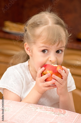 Foto: A child eats a juicy fresh apple. A child eats a juicy fresh apple.
