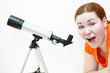 Surprised young woman in orange t-short with telescope on white