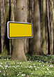 Werbung mit gelben Schild im Wald