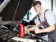 Motor mechanic working at the engine bay shows thumb up