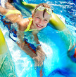 Child on water slide at aquapark.