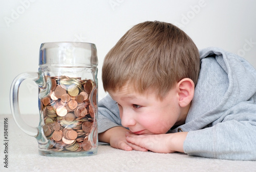 Photo: Junge liegt vor seinem Ersparten Junge liegt vor seinem Ersparten