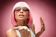 Young girl in pink wig showing something for camera