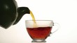 Pouring hot tea into glass cup isolated on white background