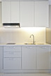 The apartment kitchen is white