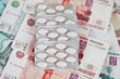 Tablets in a blister on the background of the money Tablets in a blister on the background of the money