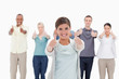 Photo: Close-up of a smiling woman giving the thumbs-up with people beh Close-up of a smiling woman giving the thumbs-up with people beh