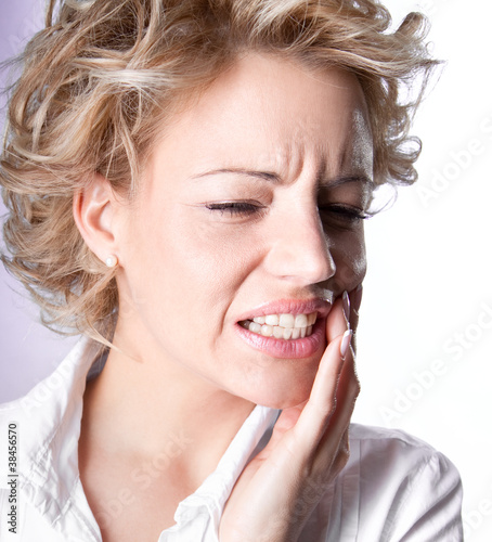 Photo: Young woman in pain is having toothache Young woman in pain is having toothache
