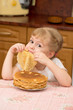 Foto: The little girl is naughty behind a table on kitchen The little girl is naughty behind a table on kitchen
