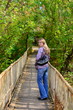 Girl goes on a wooden bridge and turns