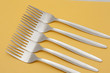 Five forks arranged on a yellow background