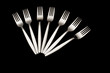 Five forks arranged on a black background