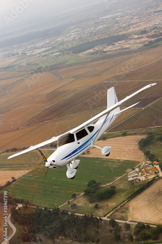 Foto: Small airplane flying over farm Small airplane flying over farm