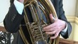 Persona che suona la tuba Wagneriana, strumento a fiato.