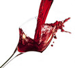 Red wine pouring into glass, isolated on white background