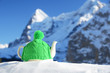 Tea pot in the knitted cap on the snow against mountain peak Tea pot in the knitted cap on the snow against mountain peak