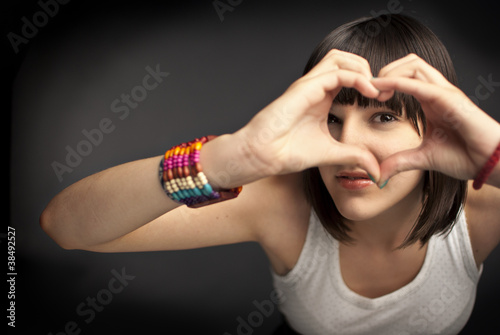 Photo: Beautiful girl forming heart with her hands Beautiful girl forming heart with her hands