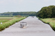 Dutch canal with pleasure yachts  through green meadows
