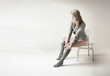 Beautiful blonde woman pulls her gray socks up