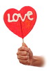 Woman hand with  red sweet valentine lollipop