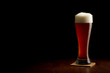 Beer into glass on a black and wooden table Beer into glass on a black and wooden table