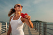 Beautiful woman in sunset light on a pier with watermelon heart
