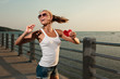 Beautiful woman in sunset light on a pier with watermelon heart