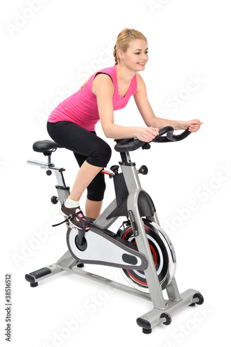 Photo: young woman doing indoor biking exercise young woman doing indoor biking exercise