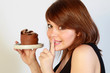 Jeune femme mangeant un gâteau au chocolat