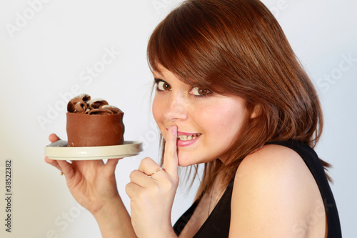 Photo: Jeune femme mangeant un gâteau au chocolat Jeune femme mangeant un gâteau au chocolat